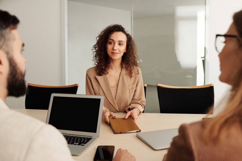 Une candidate échange avec des recruteurs pendant un entretien dans un bureau
